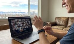 Remote employee in Denver using smartwatch during Zoom meeting
